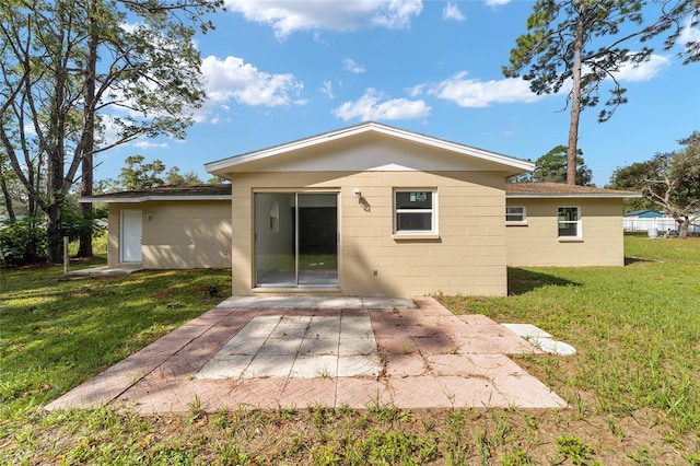 rear view of property featuring a lawn and a patio