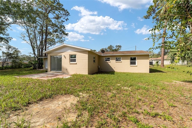 back of property featuring a patio and a lawn