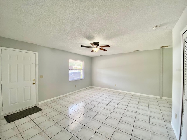 tiled empty room with a textured ceiling and ceiling fan