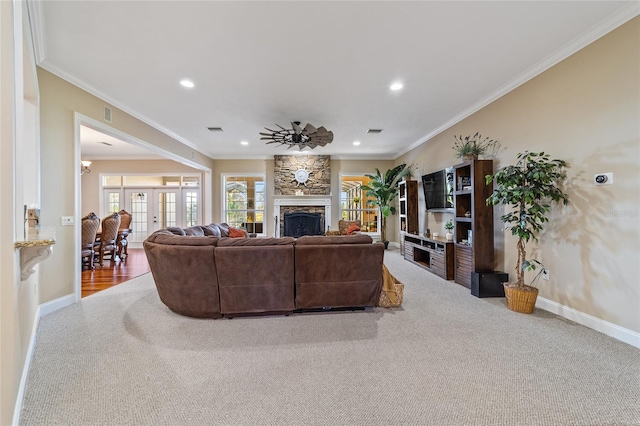 carpeted living room featuring ornamental molding, french doors, a fireplace, and ceiling fan