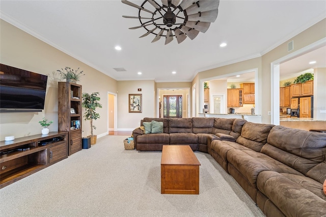 living room with light carpet, ornamental molding, and ceiling fan