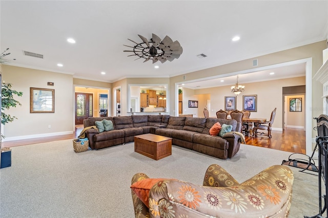 living room with crown molding, ceiling fan with notable chandelier, and light wood-type flooring