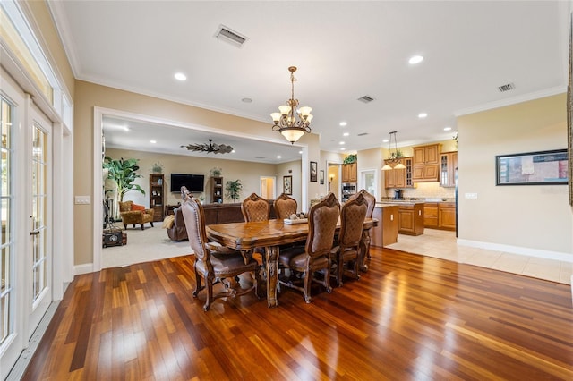 dining area featuring light hardwood / wood-style floors, a notable chandelier, and ornamental molding