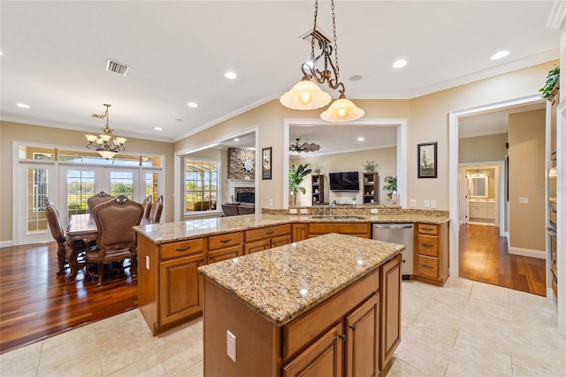 kitchen featuring light hardwood / wood-style floors, crown molding, dishwasher, and pendant lighting