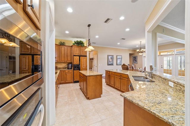 kitchen featuring light stone countertops, sink, pendant lighting, and a kitchen island