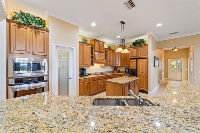 kitchen with stainless steel appliances, crown molding, sink, decorative light fixtures, and light stone counters