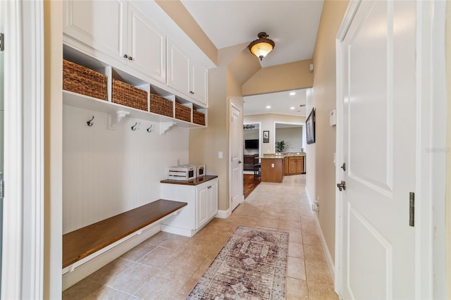 mudroom featuring vaulted ceiling and light tile patterned floors