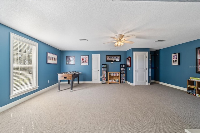 misc room with a textured ceiling, carpet floors, and ceiling fan