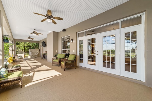 unfurnished sunroom featuring french doors, ceiling fan, and plenty of natural light