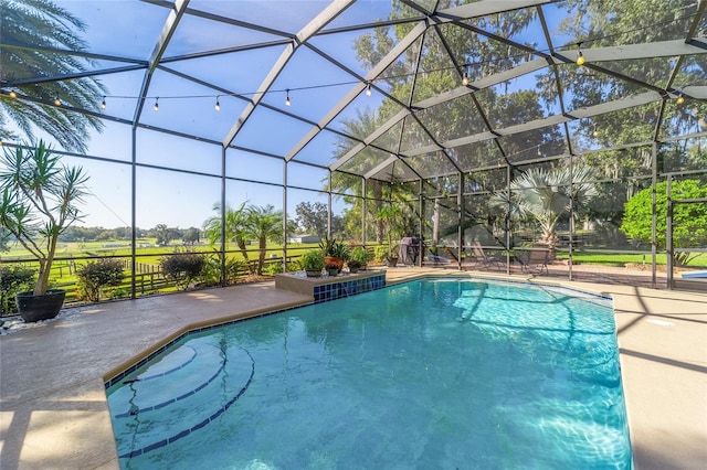 view of swimming pool with a patio area and glass enclosure