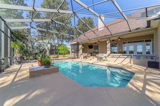 view of pool with a patio area, glass enclosure, and ceiling fan