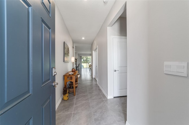 hall with a textured ceiling and tile patterned flooring