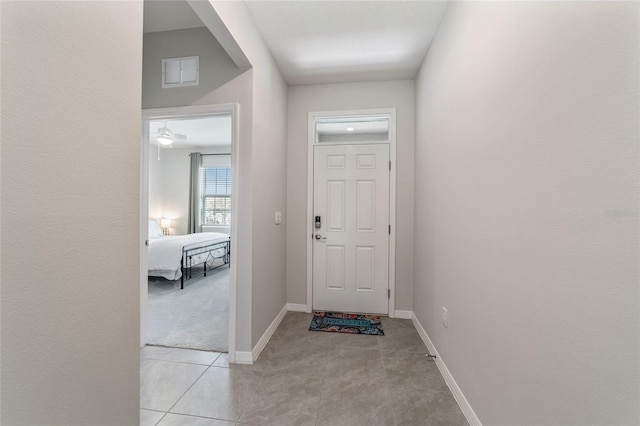 doorway to outside with light tile patterned flooring and ceiling fan