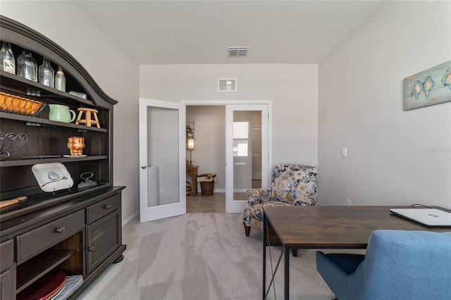 office area featuring light carpet, a textured ceiling, and french doors