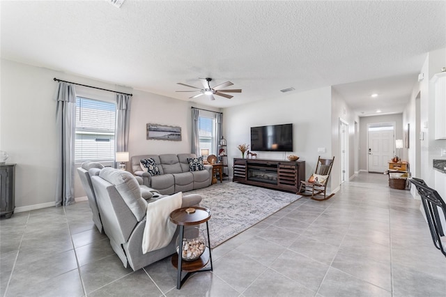 living room featuring a textured ceiling, a healthy amount of sunlight, and ceiling fan