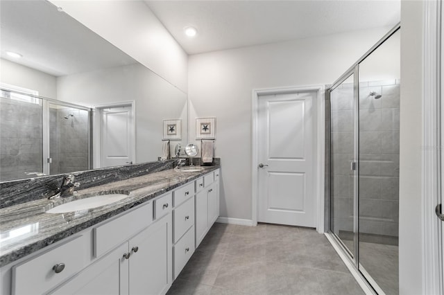 bathroom with tile patterned floors, a shower with door, and vanity