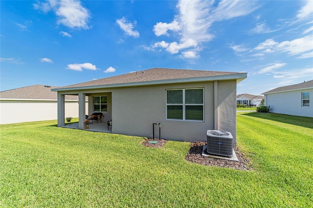 back of house with cooling unit, a lawn, and a patio