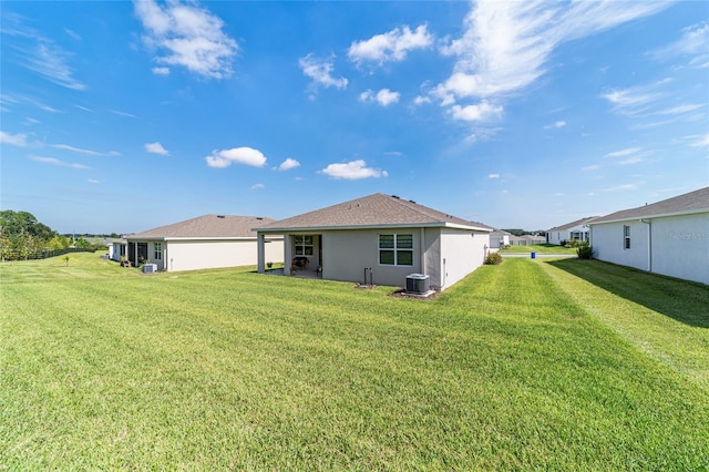 back of property featuring a lawn and cooling unit