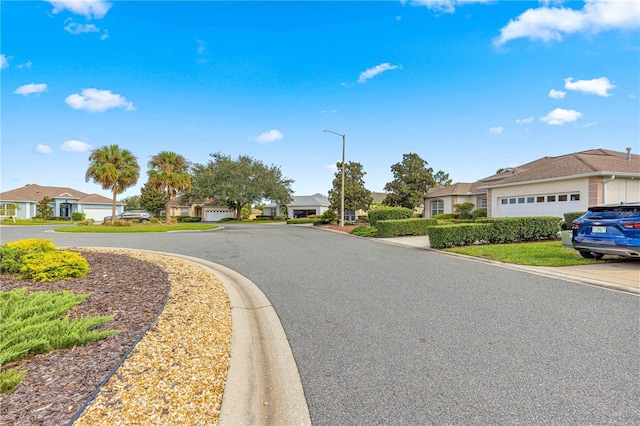view of street with a residential view, street lights, and curbs