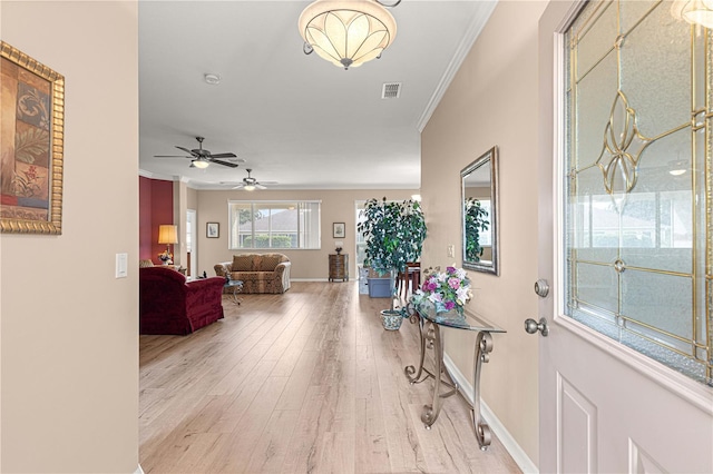 entryway featuring visible vents, baseboards, ornamental molding, ceiling fan, and wood finished floors
