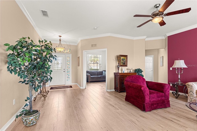 living room with ceiling fan, ornamental molding, and light wood-type flooring