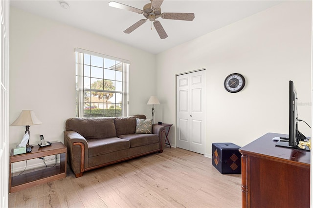 living area featuring light wood-style flooring and a ceiling fan