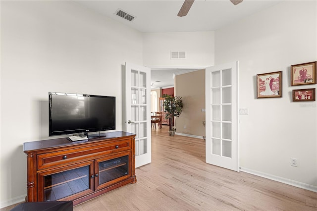 living area with visible vents, light wood-style flooring, french doors, and a ceiling fan