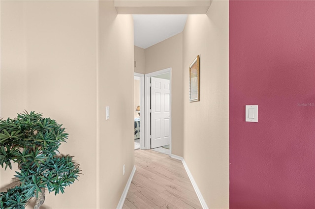 hallway with baseboards and light wood-style floors