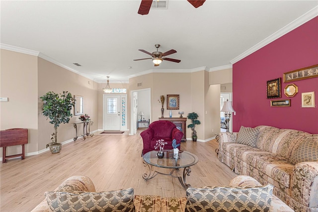 living area featuring a ceiling fan, baseboards, visible vents, light wood-style floors, and ornamental molding