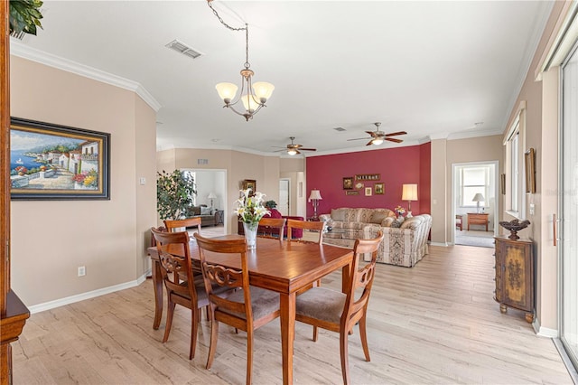 dining space featuring ornamental molding, ceiling fan with notable chandelier, baseboards, visible vents, and light wood-style flooring