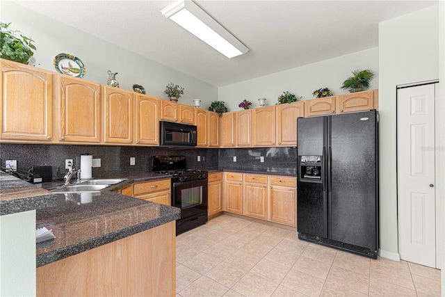 kitchen featuring tasteful backsplash, light tile patterned floors, a sink, dark countertops, and black appliances