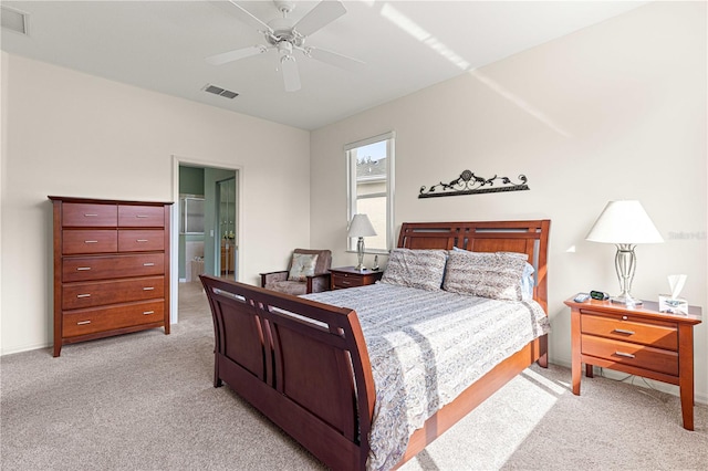 bedroom featuring ensuite bathroom, ceiling fan, and light colored carpet