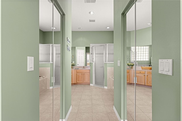 corridor with light tile patterned floors, a sink, and visible vents