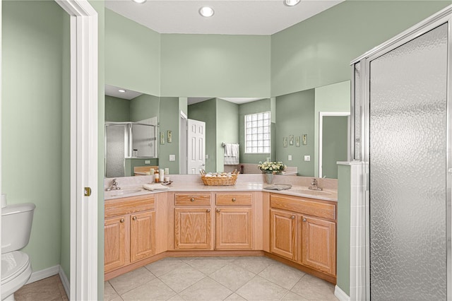 bathroom featuring tile patterned flooring, vanity, toilet, and a shower with door