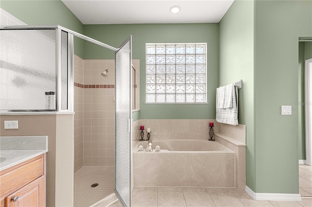 bathroom featuring plus walk in shower, vanity, and tile patterned floors