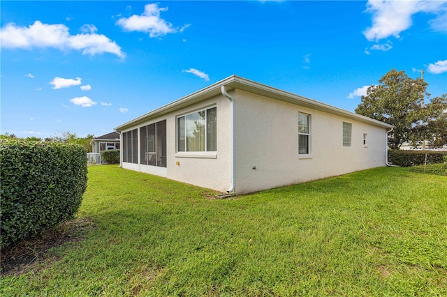 view of side of property with a lawn and a sunroom