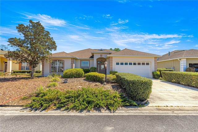 ranch-style home with driveway, stucco siding, and an attached garage
