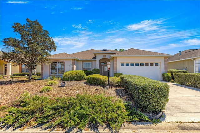 single story home featuring driveway, stucco siding, and a garage