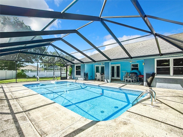 view of swimming pool with a lanai, a patio area, and french doors