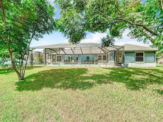 back of house featuring a lawn and a lanai