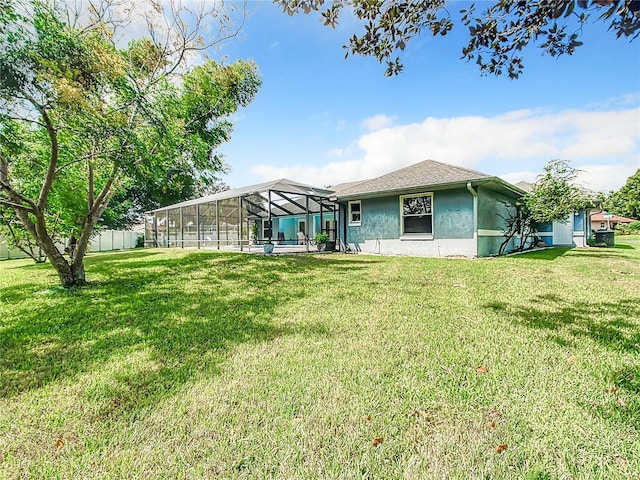 back of house with a lawn, a pool, and a lanai