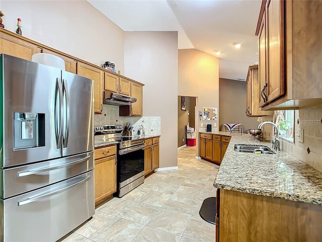 kitchen featuring light stone counters, sink, decorative backsplash, appliances with stainless steel finishes, and light tile patterned floors