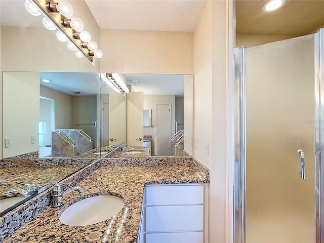 bathroom featuring vanity and a shower with door