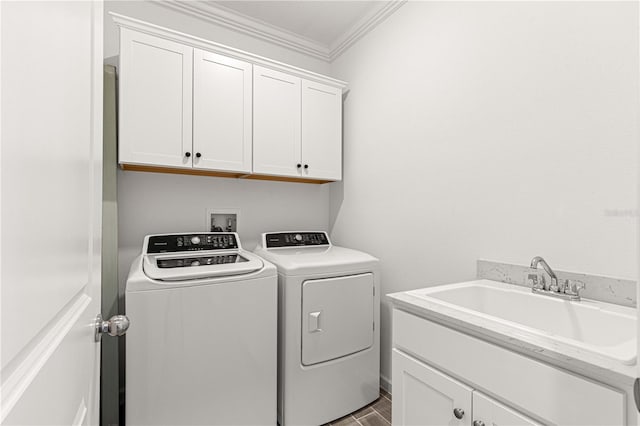 clothes washing area with crown molding, separate washer and dryer, sink, and cabinets