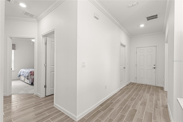 corridor featuring ornamental molding and light hardwood / wood-style flooring