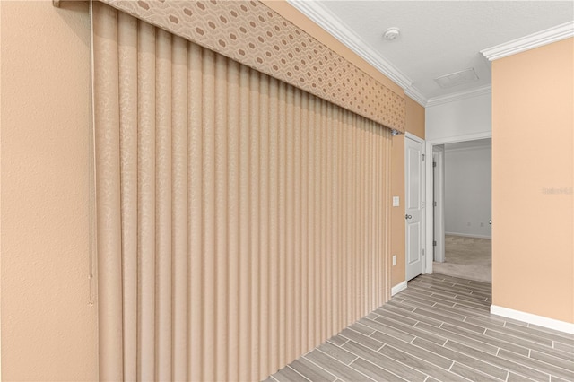 hallway featuring ornamental molding and hardwood / wood-style floors