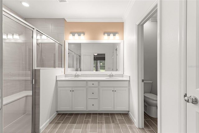 bathroom featuring walk in shower, crown molding, vanity, and toilet