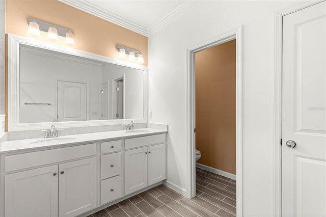 bathroom with ornamental molding, hardwood / wood-style floors, vanity, and toilet