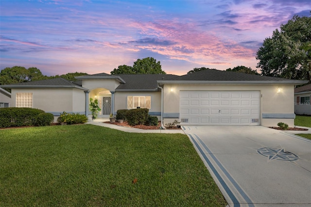 ranch-style house with a garage and a lawn