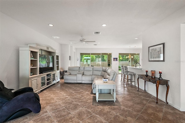 living room featuring ceiling fan with notable chandelier